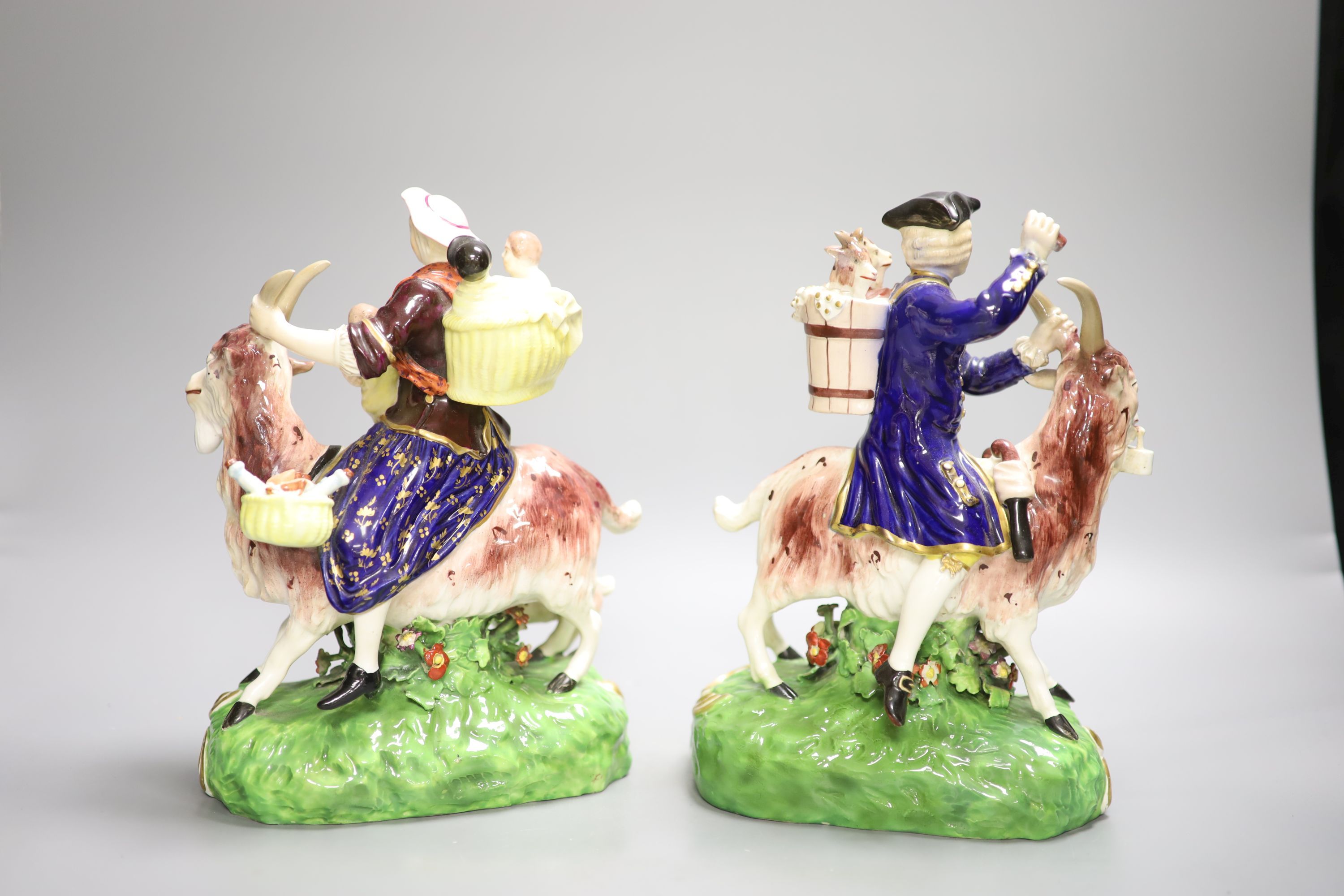 A pair of Derby figures, Welsh Tailor and Companion figures both figures seated on a goat,